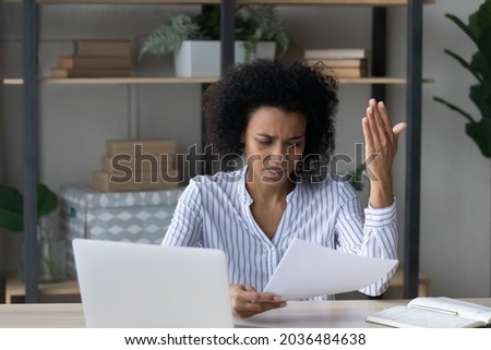 Bad business letter. Distressed worried young african businesswoman read bad news about insolvency bankruptcy in official paper document. Nervous black female employee get debt notification from bank Royalty-Free Stock Photo #2036484638