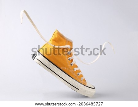 Classic old school sneaker with flying laces on gray background Royalty-Free Stock Photo #2036485727