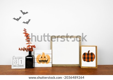 Halloween mock up. Shabby chic wood signs, calendar and orange branch decor on a wood shelf against a white wall. Copy space.