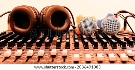 Black headphone and two microphone on console sound board mixer