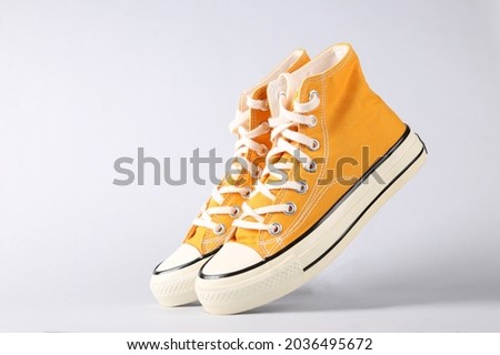 Classic old school sneakers on gray background Royalty-Free Stock Photo #2036495672
