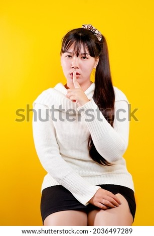 asian girl That cheerful, fun, bright smile. expression of loving eyes good living and happiness at work, relaxation, against a yellow background