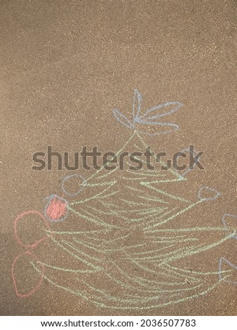 Christmas tree painted on the asphalt with colored chalk.Art therapy, children draw adish crayons on the asphalt for the new year and Christmas in the summer