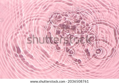 Texture of drops on pink water under sunlight. Top view, flat lay. 