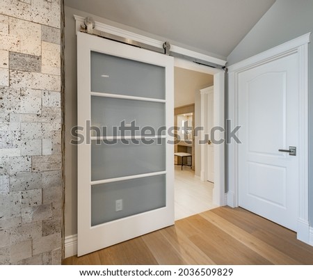Luxurious interior bathroom with barn door white tile glass shower and makeup counter Royalty-Free Stock Photo #2036509829