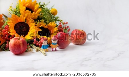 Autumn flowers, Cute little dolls, apples on marble background. beautiful fall seasonal composition. autumn time concept. 