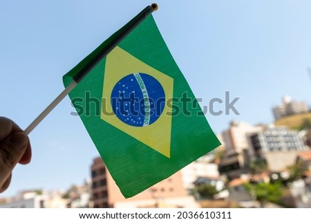 hand holding small brazil flag. Order and progress in Portuguese. Brazilian flag. proclamation of the Republic. proclamação da república