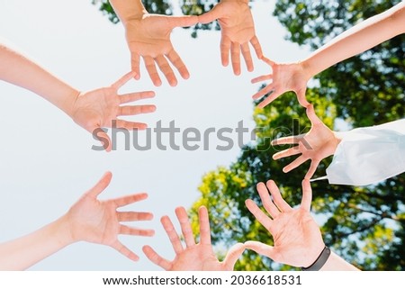 Picture from above of the people hands turned with their palms in the circle towards the camera, they are united in support of freedom from the virus, pandemic concept.
