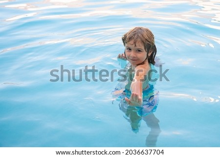 Happy kid playing in swimming pool. Child water games. Family vacation and summer activity.