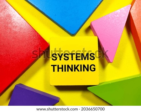 Business concept.Text SYSTEMS THINKING writing on colored tangram on a yellow background.