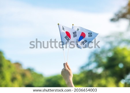 hand holding Korea flag on nature background. National Foundation, Gaecheonjeol, public Nation holiday, National Liberation Day of Korea and happy celebration concepts Royalty-Free Stock Photo #2036654003