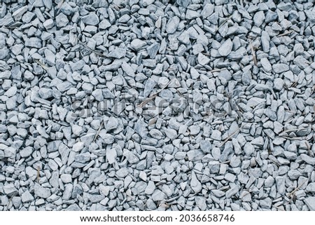 Gray crushed gravel stones on ground texture background. Small rocks used for construction of buildings