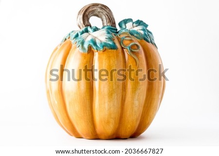 Decorative orange ceramic pumpkin isolated against white background. Thanksgiving and Halloween concept
