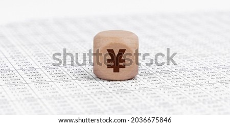Business and finance concept. There is a cube with the yen sign on the accounting documents.