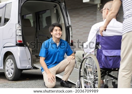 A caregiver who picks up and picks up the elderly in a long-term care taxi Royalty-Free Stock Photo #2036709989