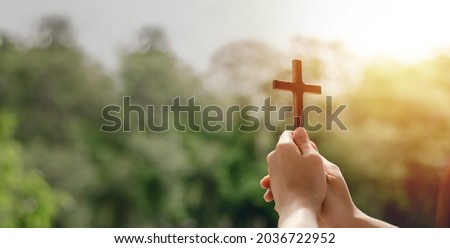girl holding a cross to pray thank god Praise the Lord with outdoor background, pray, easter and good holidays concept