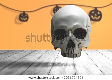 Human skull on a wooden table with colored background