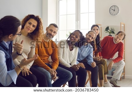 Team of happy diverse people talking sitting on row of chairs in office meeting. Group of colleagues, community members and friends communicating, sharing ideas and listening to each other's opinions Royalty-Free Stock Photo #2036783450