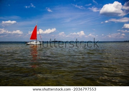 Small ship with red sail