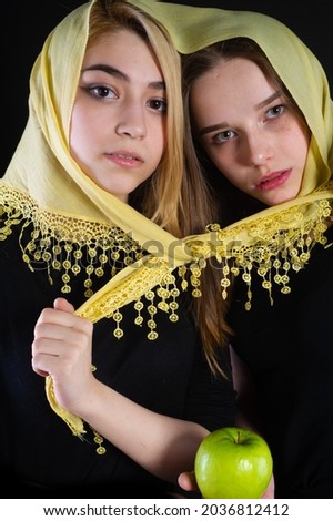 Portrait of two girls tied with one scarf. Playful mood. Youth