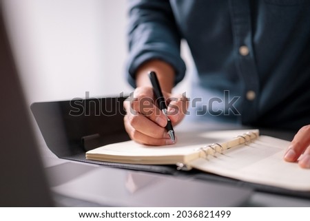 Man hand writing on a notebook