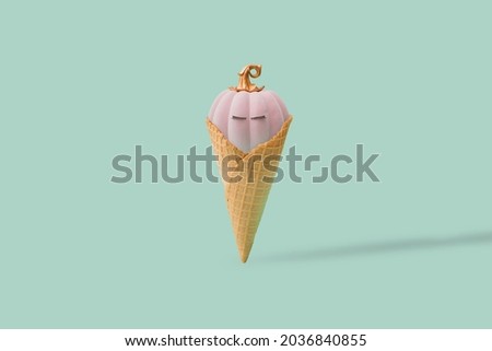 Scary and cute pink Halloween pumpkin in ice cream cone. Mint green background. Minimal design. Copy space.