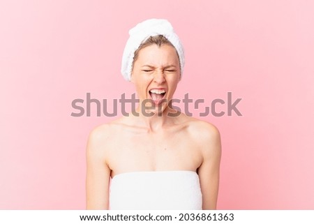 young blonde woman shouting aggressively, looking very angry and after shower