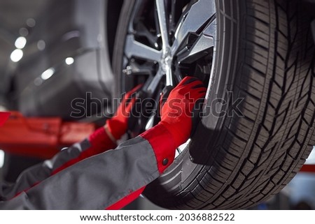 Crop technician changing wheel on car Royalty-Free Stock Photo #2036882522