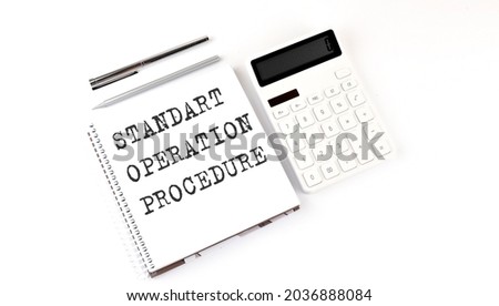 Notepad with text STANDART OPERATION PROCEDURE with calculator and pen. White background. Business