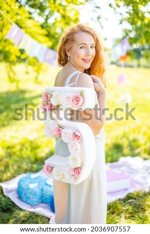 Beautiful woman with paper number with flowers in hand - decorations made with your own hands. Small business concept. High quality photo