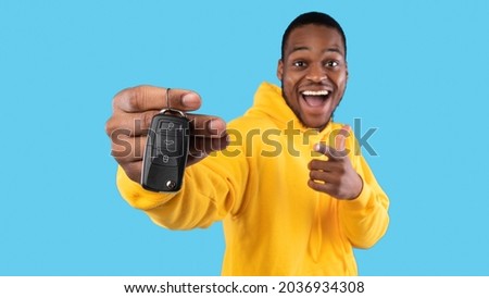 New Car. Excited Black Man Showing Key In Excitement Celebrating Buying New Auto Posing Standing On Blue Studio Background. Dreams Come True, Own Automobile Concept. Panorama, Selective Focus Royalty-Free Stock Photo #2036934308