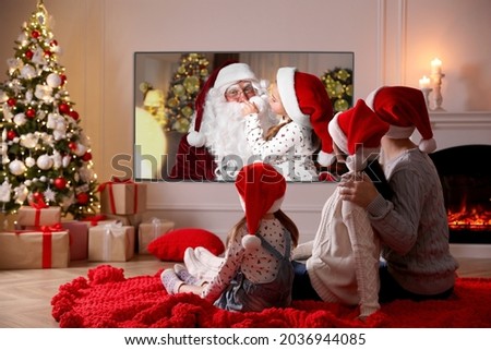 Family watching TV movie in room decorated for Christmas