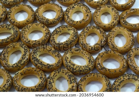 Background. Cookies in the form of rings made of flour with poppy seeds are neatly laid out