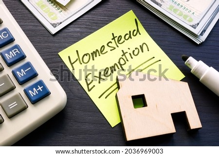 Homestead exemption written on the sticker and model of home. Royalty-Free Stock Photo #2036969003