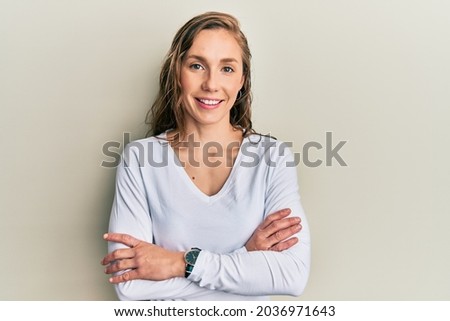 Young blonde woman wearing casual clothes happy face smiling with crossed arms looking at the camera. positive person. 