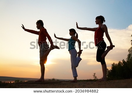 silhouette of  young couple's yoga on the background beautiful sunset