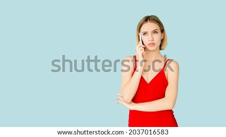 Mobile talk. Skeptic woman. Virtual communication. Advertising background. Doubtful lady having call by smartphone isolated blue copy space. Royalty-Free Stock Photo #2037016583