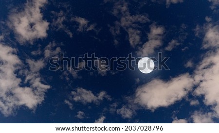 Bright sky with clouds and full moon over the sea in the evening. calm nature background outdoors at night