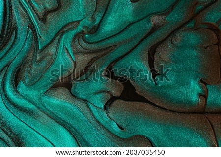 Beautiful shimmer turquoise stains of liquid nail polish.Stripy paint texture.Nail lacquer flow background in fluid art technique.Minimalism concept.Copy space,horizontal photography.
