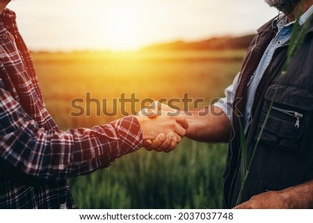 Close up farmers handshake outdoor on a field Royalty-Free Stock Photo #2037037748