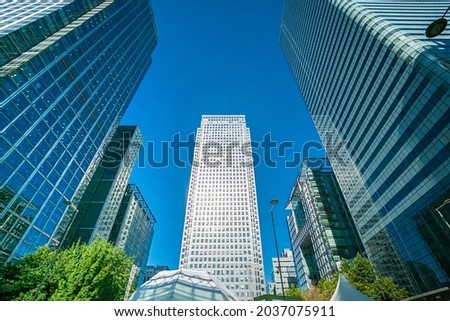 Office buildings, skyscrapers, blue sky, sunny day in the business district of London Canary Wharf, UK. Can be used for websites, brochures, posters, printing and design. Royalty-Free Stock Photo #2037075911