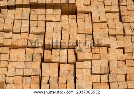Piles of wooden planks at the sawmill for the manufacture of cladding. Warehouse of boards in the open air for the construction of houses. Timber in stacks, construction materials industry.
