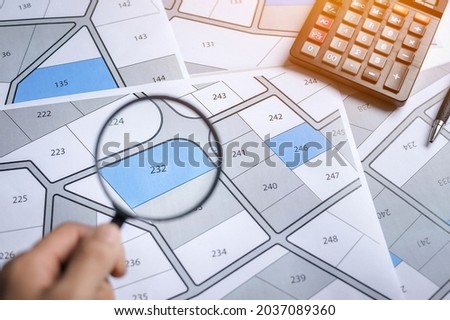 hand with magnifier on cadastre map search for assess to buy the land concept with copy space Royalty-Free Stock Photo #2037089360