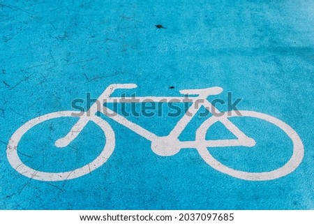 Bicycle symbols on the floor of a bicycle lane painted in blue.