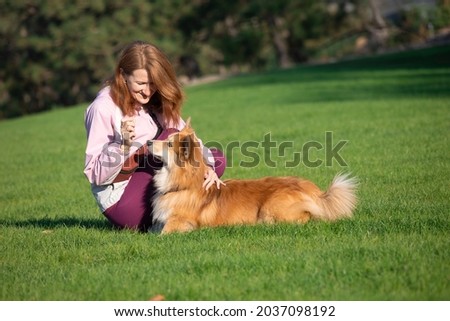 girl and dog corgi walking in the park
