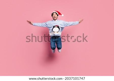 Photo of handsome sweet gentleman wear new year sweater smiling jumping arms sides isolated pink color background