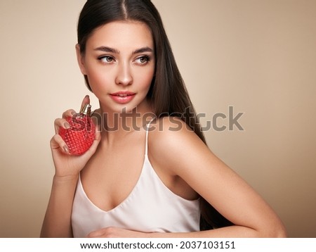Young beautiful woman with a bottle of perfume. Model with healthy skin, close up portrait. Cosmetology, beauty and spa Royalty-Free Stock Photo #2037103151