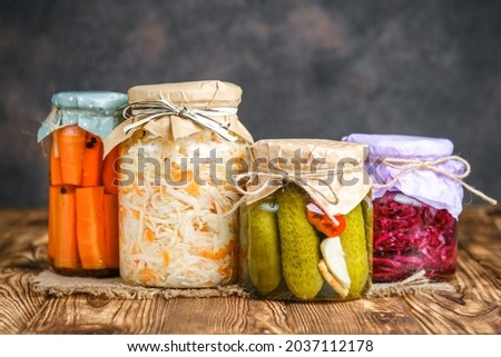 Fermented foods. Sauerkraut, red cabbage, cucumbers and carrots on a rustic background. Royalty-Free Stock Photo #2037112178