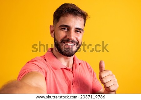 closeup of handsome man making selfie with thumb up making thumbs up ok.
