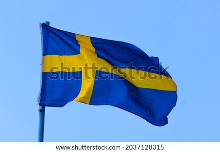 The flag of Sweden is a rectangular blue banner with a yellow Scandinavian cross